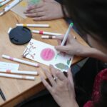 Kobieta tworzy kolorową kartkę pop up przy drewnianym stole