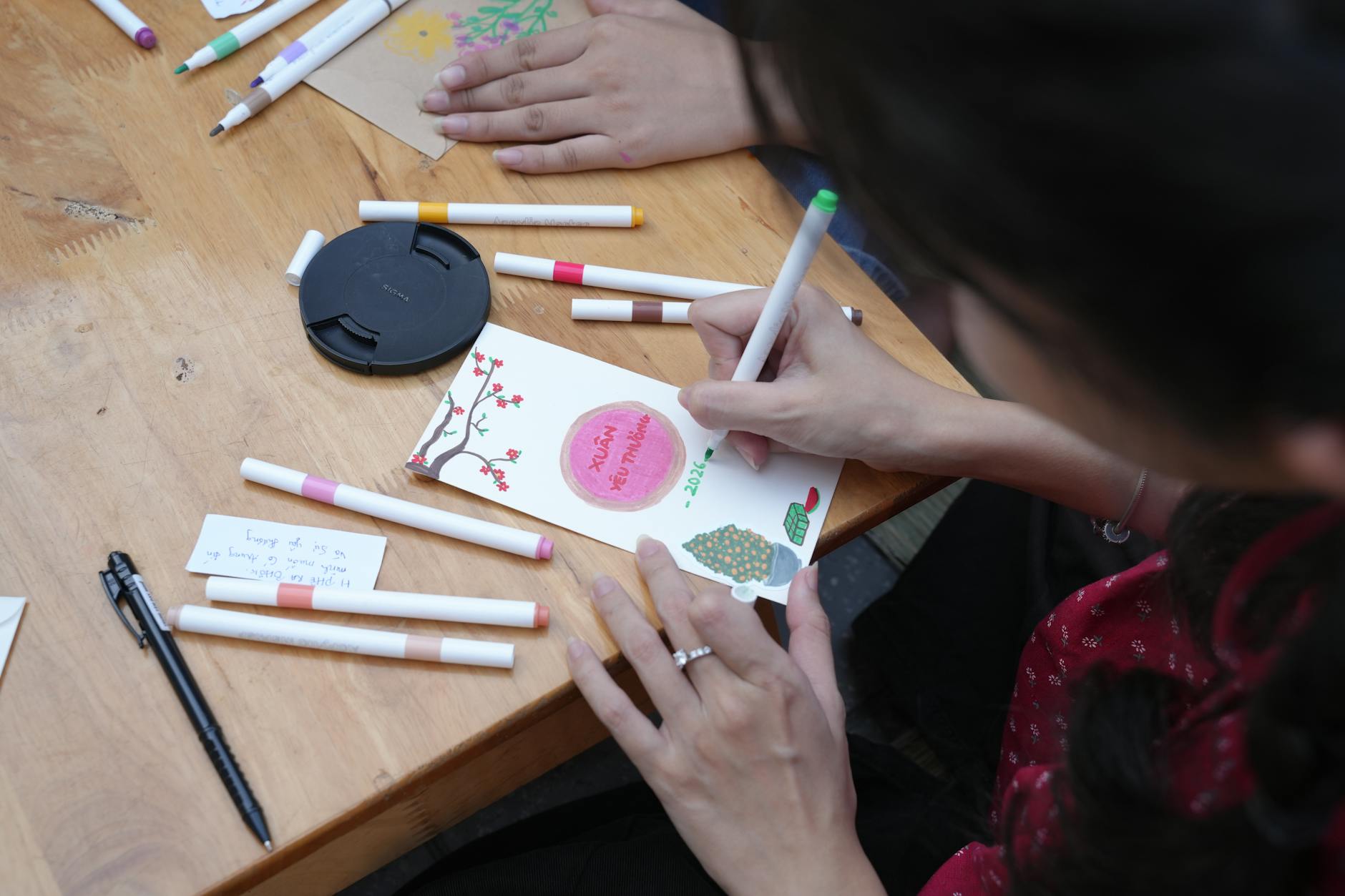 Kartka pop up: prosta technika, wielki efekt dla dzieci Kobieta tworzy kolorową kartkę pop up przy drewnianym stole