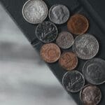 Talerz, moneta i woda: szybki trik, który uczy o napięciu Różne monety z całego świata rozsypane na fakturowanym tle